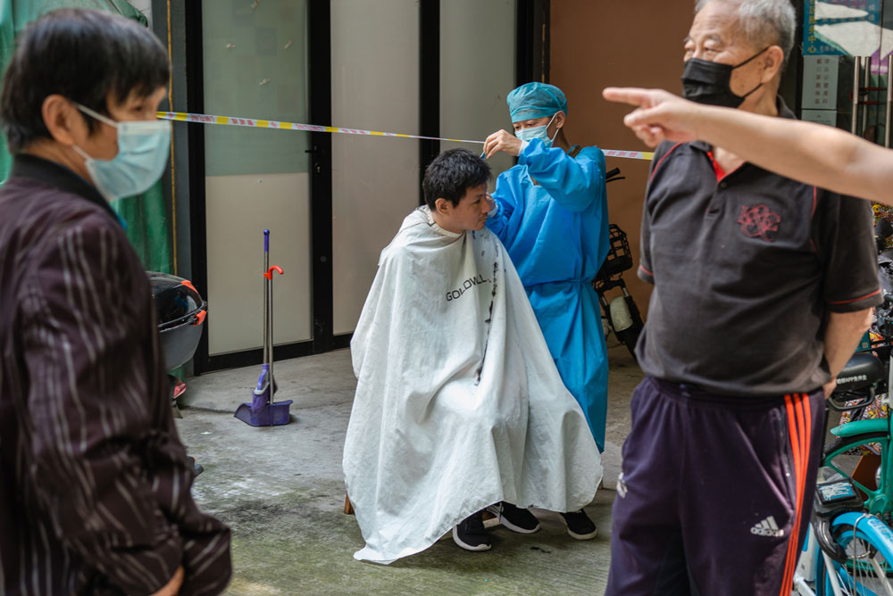 A barber at work on the street in Shanghai, May 21, 2022. Gao Zheng for Sixth Tone