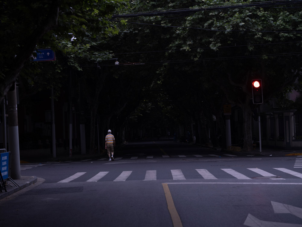 A man walks down the street in the early morning, Shanghai, June 1, 2022. Zhou Pinglang for Sixth Tone