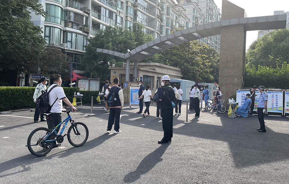 High school students line up to show their green health code and pass through temperature check at a school in Hongkou District, Shanghai, June 6, 2022. Luo Meihan/Sixth Tone