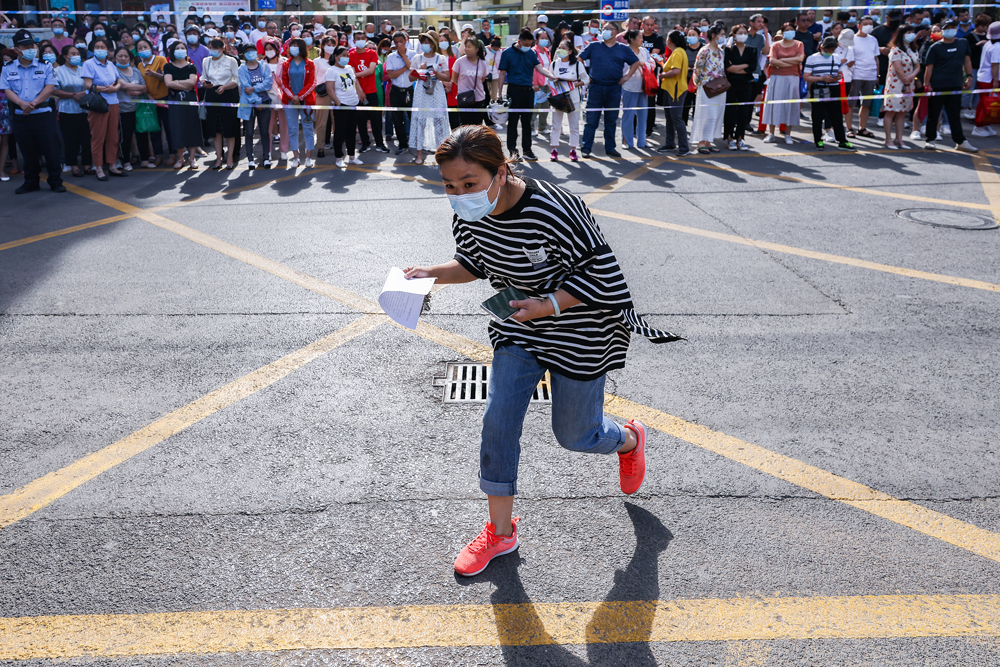 A parent delivers their child’s admission card for the national college entrance examination in Taiyuan, Shanxi Province, June 7, 2022. Hu Yuanjia/VCG