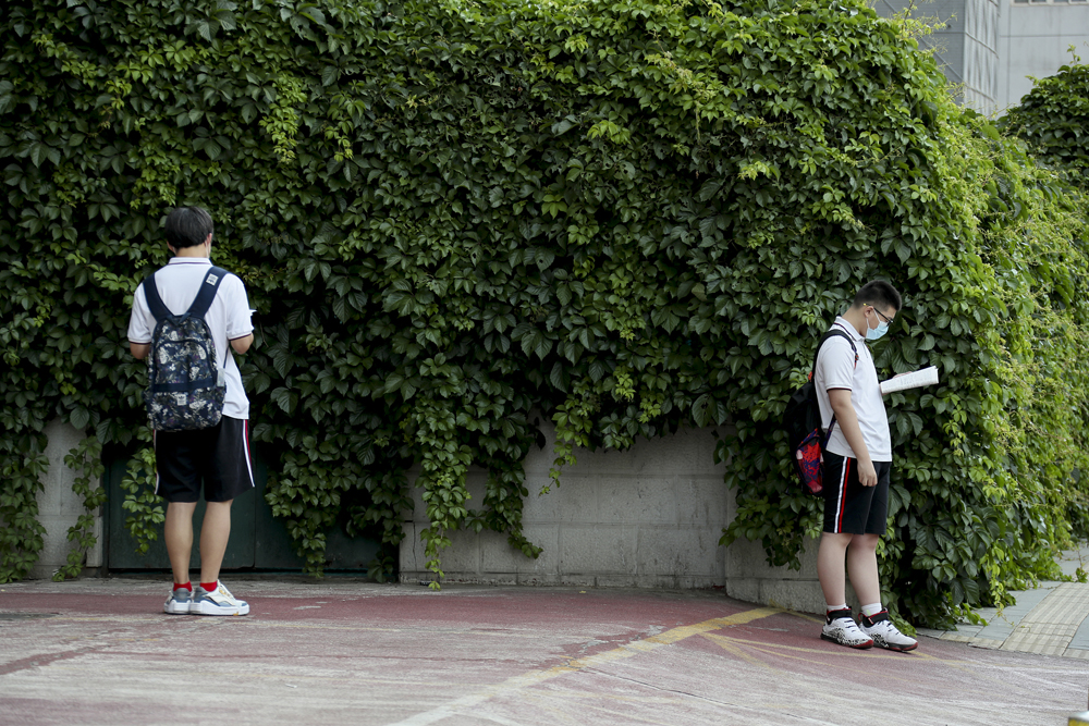Students do some last-minute revision before they enter the exam hall in Beijing, June 7, 2022. Lin Hai/VCG