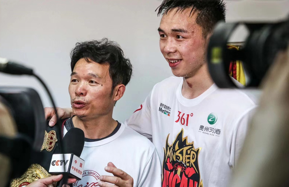 Xu Can and his father Xu Xiaolong speak with Chinese media after Xu Can successfully defended his world title against Japan’s Shun Kubo in 2019. Courtesy of Xu Can