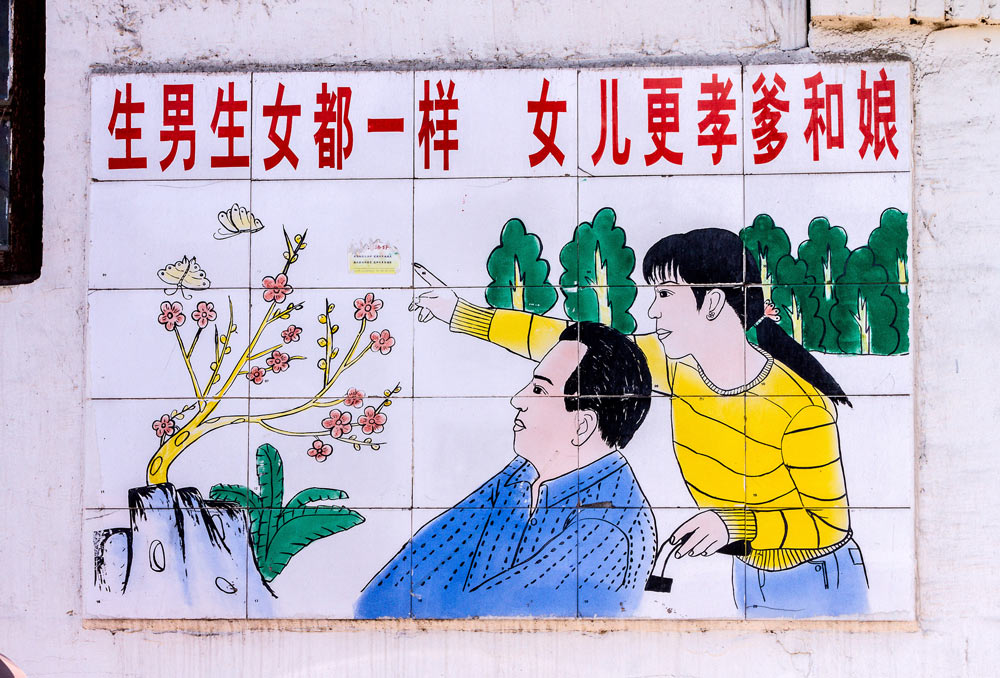 A poster promoting family planning in Zoucheng, Shandong province, 2014. The slogan reads “Sons and daughters are equally valuable — daughters are more filial to their parents.” VCG