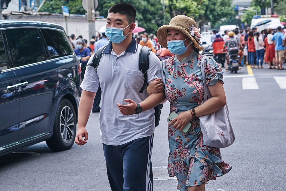 A mother and son leave the exam room after the Chinese test of “Gaokao” in Shanghai, July 7, 2022. Wu Huiyuan/Sixth Tone