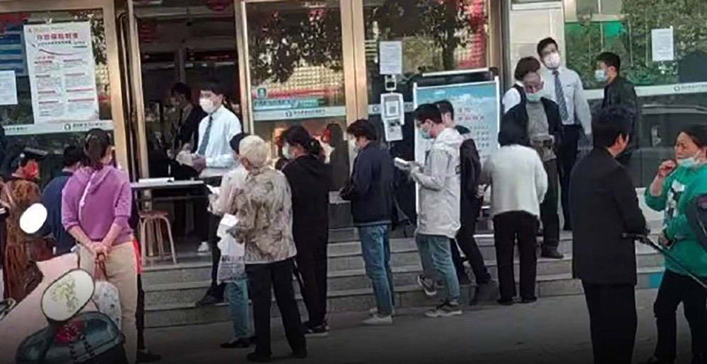 People gather at a branch of Yuzhou Xinminsheng Villlage Bank after discovering they couldn't withdraw their money, in Yuzhou, Henan province, 2022. From Weibo