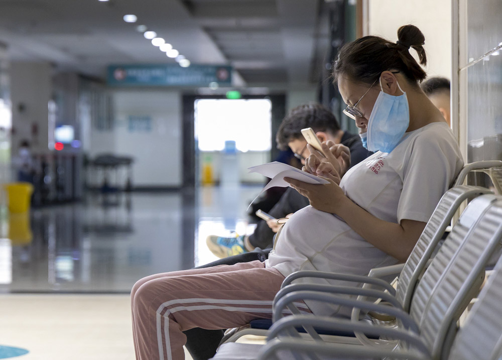A pregnant woman checks her examination results at a hospital in Yangzhou, Jiangsu province, June 2020. Chen Yang/VCG