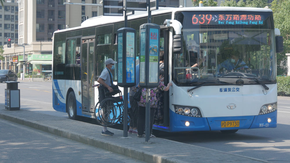 Seniors board a bus in Shanghai, July 2022. Gu Peng for Sixth Tone