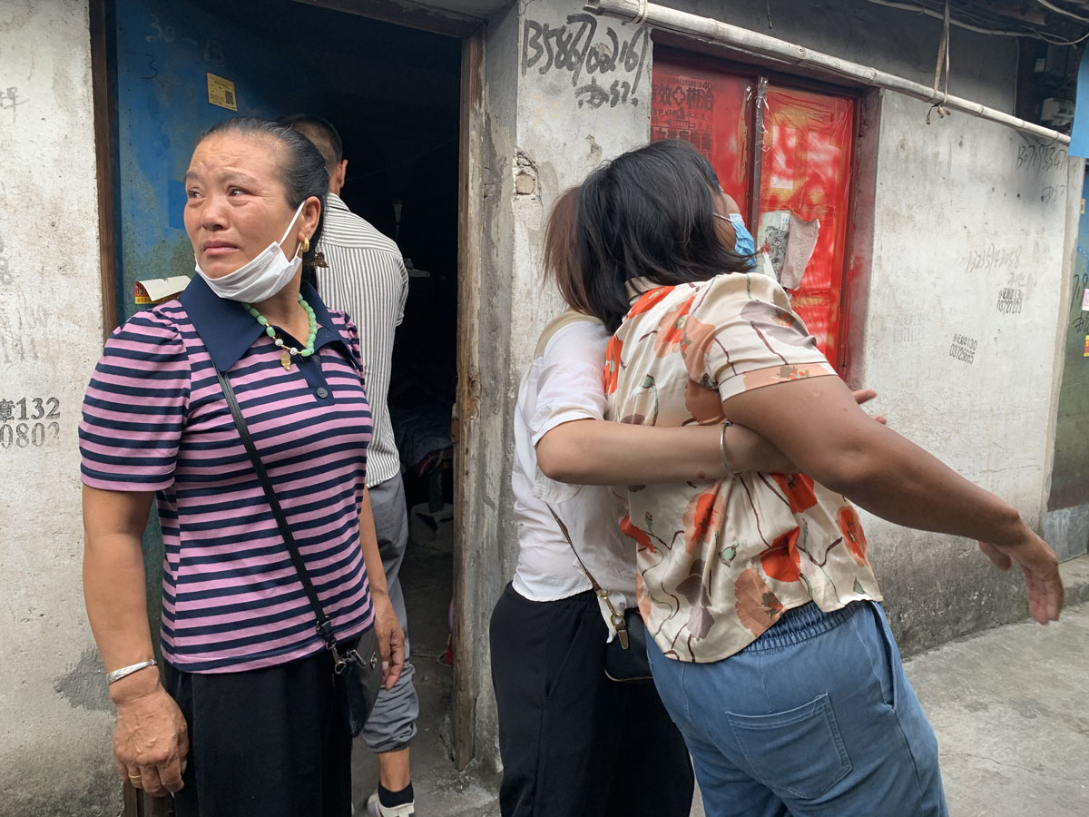 Family members of Zhang Gongqian are overcome by grief as they visit his rented room, Zhejiang province, July 26, 2022. Yuan Ye/Sixth Tone
