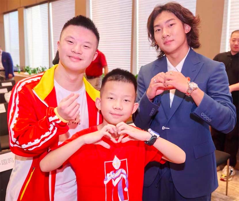Su Yiming (right), the newly-appointed Chinese ambassador for the Special Olympics, poses for a photo with Li Xiang (left), a Special Olympics athlete, and Li's younger brother, in Shanghai, Aug. 14, 2022.  Courtesy of the Special Olympics Committee