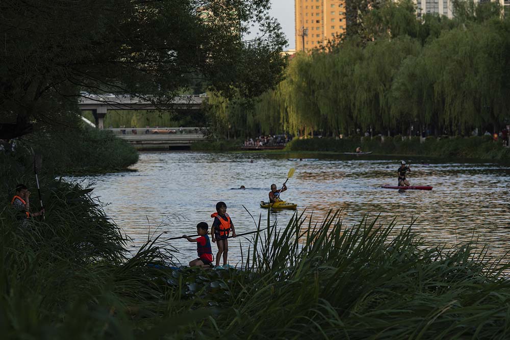 Children kayak on the Liangma River in Beijing, July 10, 2022. VCG