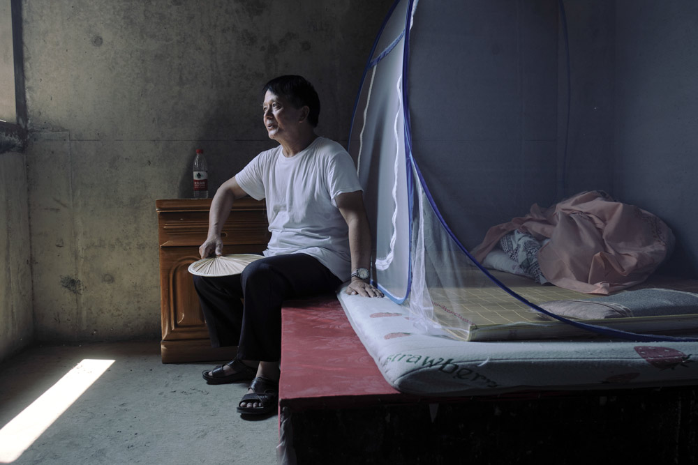 Qu rests in his room inside Jinling Apartment, August 2022. Wu Huiyuan/Sixth Tone
