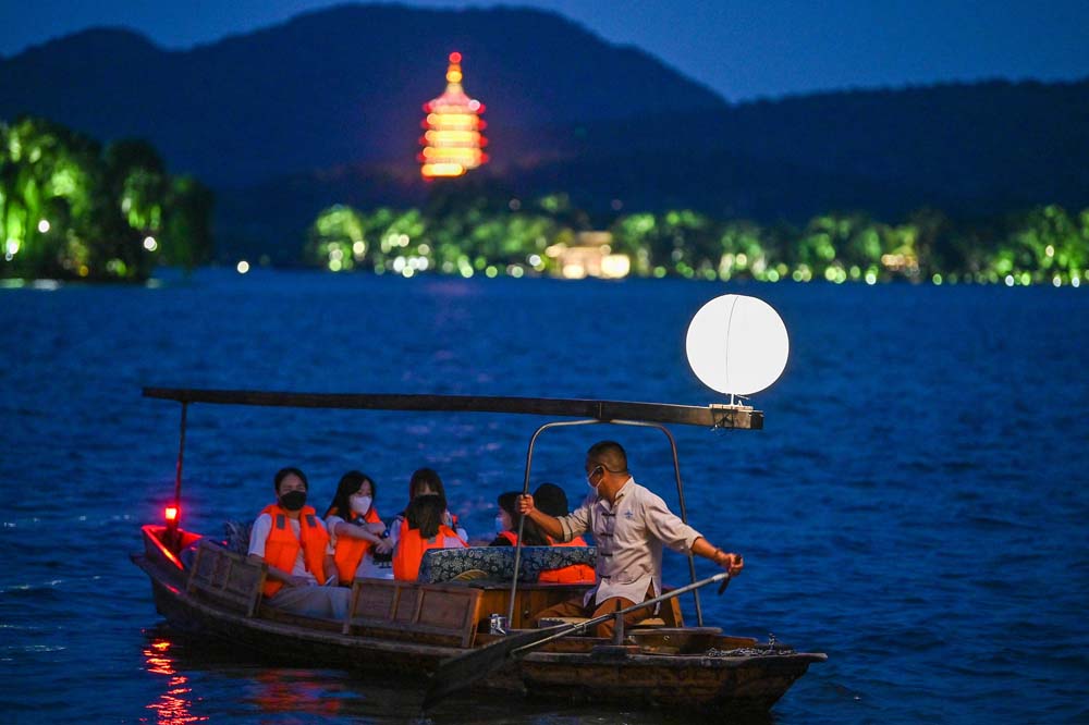 Tourists ride a moon boat at West Lake in Hangzhou, Zhejiang province, Sept. 9, 2022. VCG