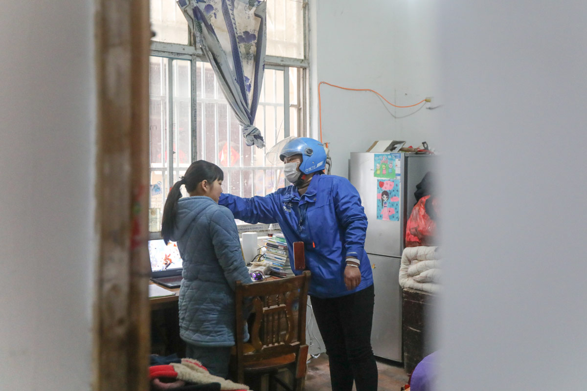 A delivery rider talks to her daughter at home in Fuyang, Anhui province, 2020. VCG