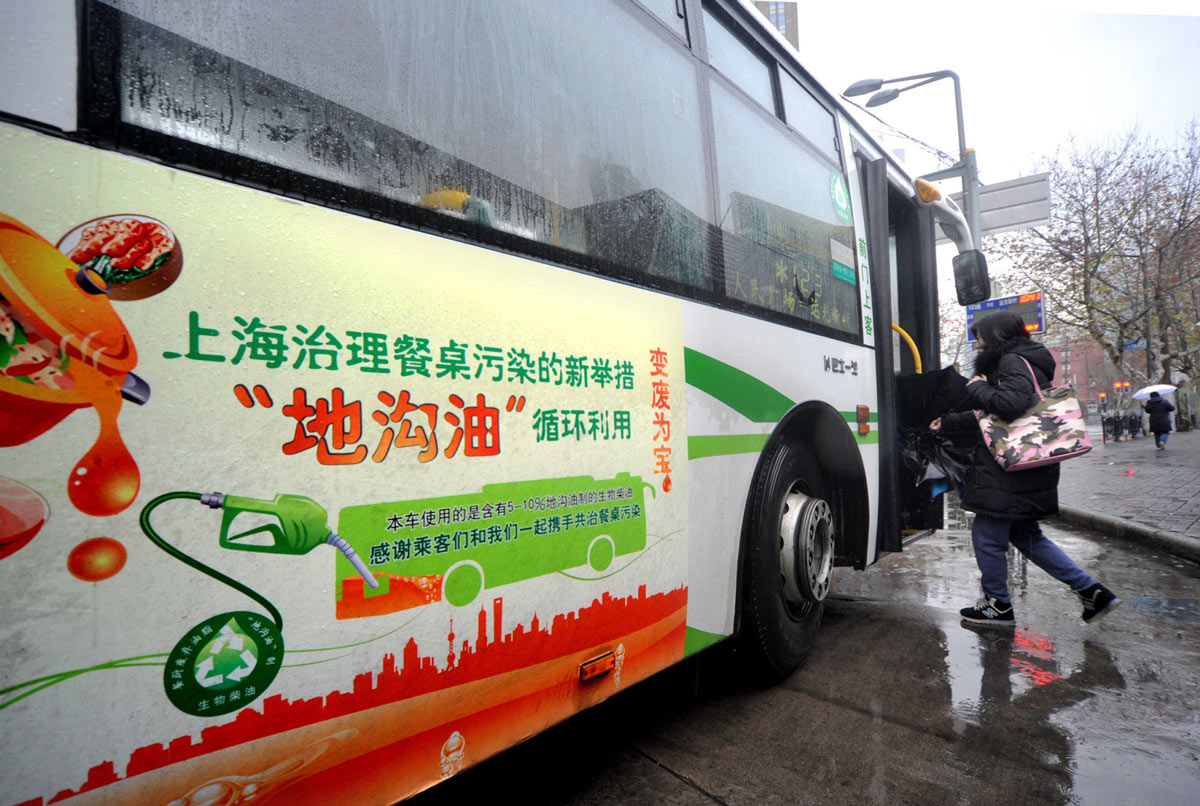 A passenger boards a bus partly fueled by used cooking oil in Shanghai, 2015. Alamy