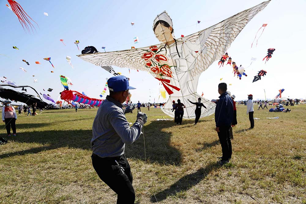 A man flies a kite featured a nurse during the 37th Weifang International Kite Festival in Weifang, Shandong province, Sept. 26, 2020. VCG