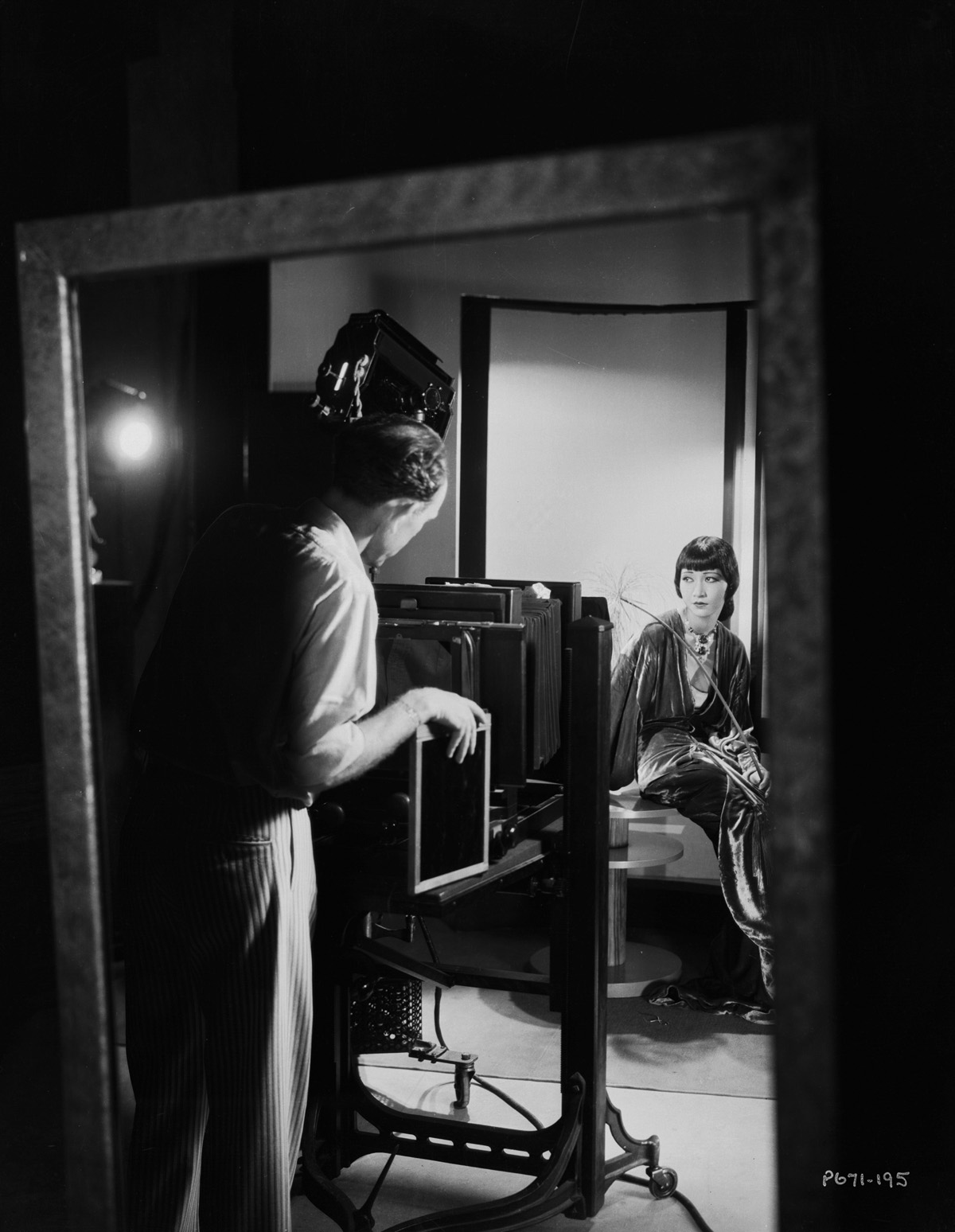 A reflection in a mirror shows Paramount photographer Otto Dyar taking a studio portrait of Anna May Wong, circa 1932. Otto Dyar/John Kobal Foundation via VCG