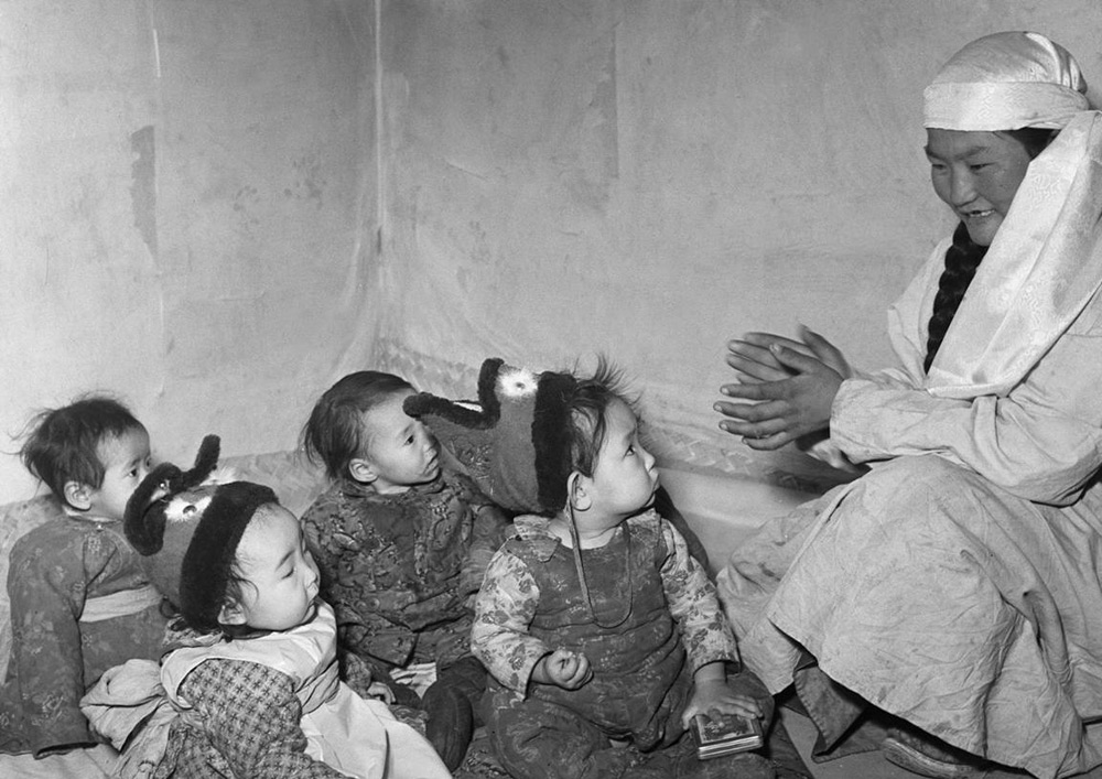 A nurse entertains a group of children at a nursery in the Inner Mongolia Autonomous Region, 1960s. Xinhua