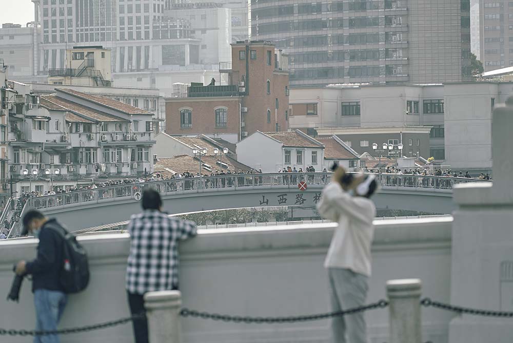 Spectators watch the second edition of the Head of Shanghai River Regatta from the bank of the Suzhou Creek, Oct. 29, 2022. Wu Huiyuan/Sixth Tone