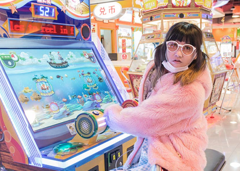 Lu Yang poses for a photo at an arcade. From the artist’s website