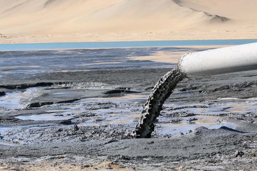 A pipe extending from a factory emits gray liquid waste into the nearby desert in Golmud, Qinghai province, Nov. 3, 2017. Courtesy of Green Data