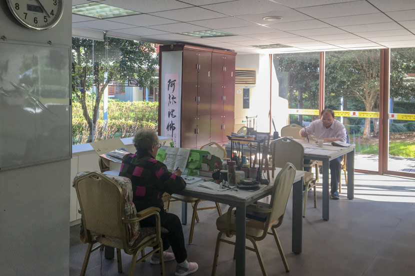 Seniors read and write calligraphy in the activity room at luxury retirement compound Qinheyuan in Shanghai, Oct. 25, 2017. Fan Yiying/Sixth Tone