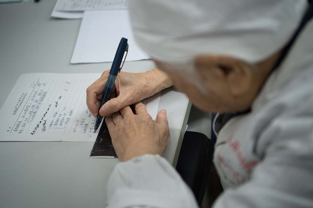 An older doctor writes prescriptions at a hospital in Taiyuan, Shanxi province, Oct. 25, 2017. VCG