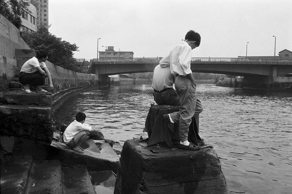 People take a moment to relax on the bank of Suzhou Creek, 1990s. Lu Yuanmin for Sixth Tone