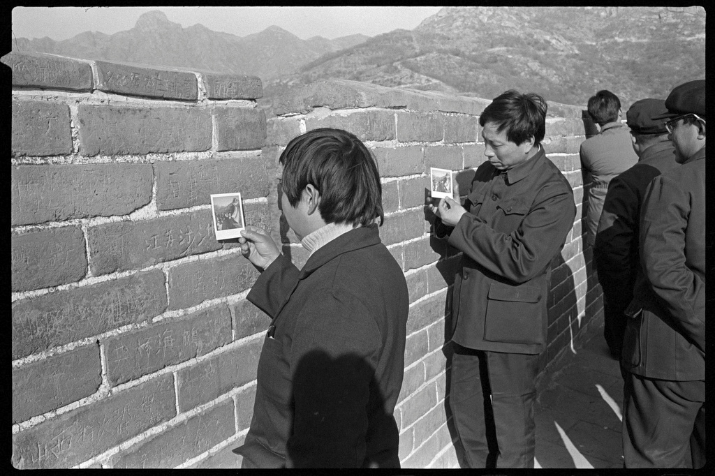 Visitors check their Polaroid instant photos snapped at the Great Wall near Beijing, 1986. Courtesy of Andrew Wong