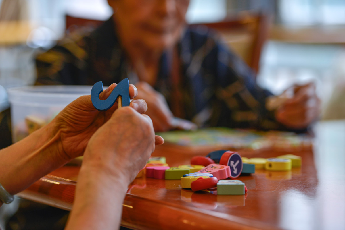 Elderly people play with educational toys at a nursing home for people diagnosed with Alzheimer’s disease, Beijing, 2015. Feng Li/VCG