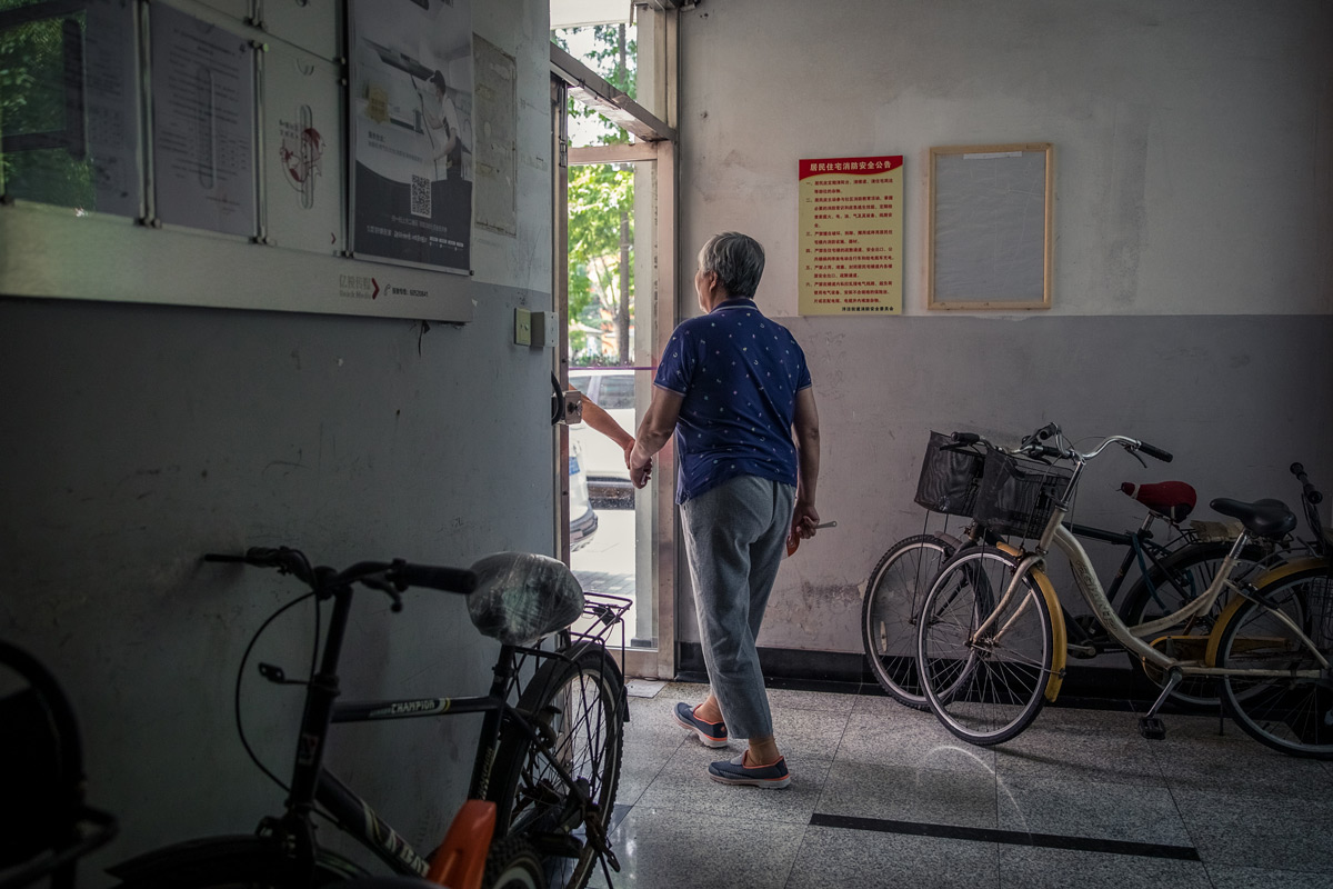 A man holds the hand of his wife, who has Alzheimer’s disease, Shanghai, 2019. Niu Jing/VCG