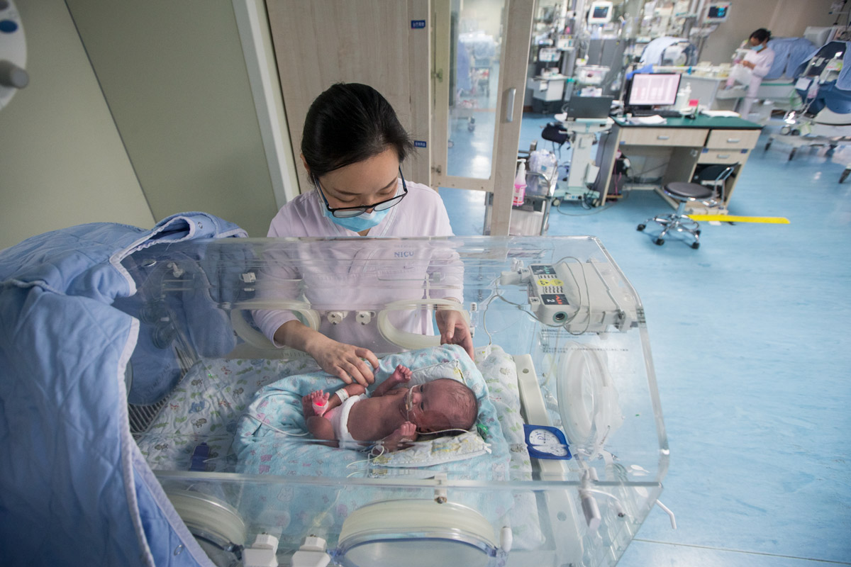 A nurse takes care of a preterm infant at an NICU in Hangzhou, Zhejiang province, 2018. Chen Zhongqiu/VCG
