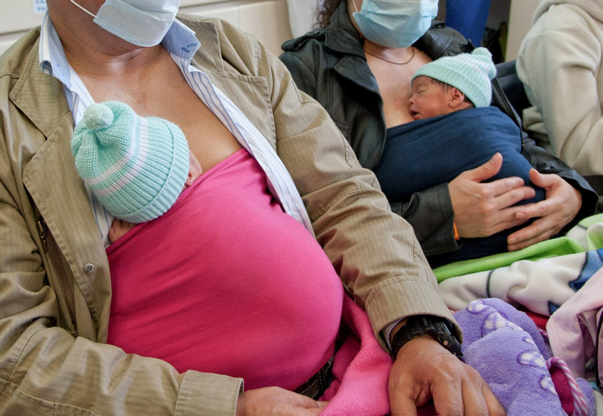 A man and his wife hold their premature babies directly against their bodies at a hospital in Bogota, Colombia, March 26, 2014. This simple practice of skin-to-skin contact started in Colombia more than 30 years ago, due to a shortage of incubators. Guillermo Legaria/AFP via VCG