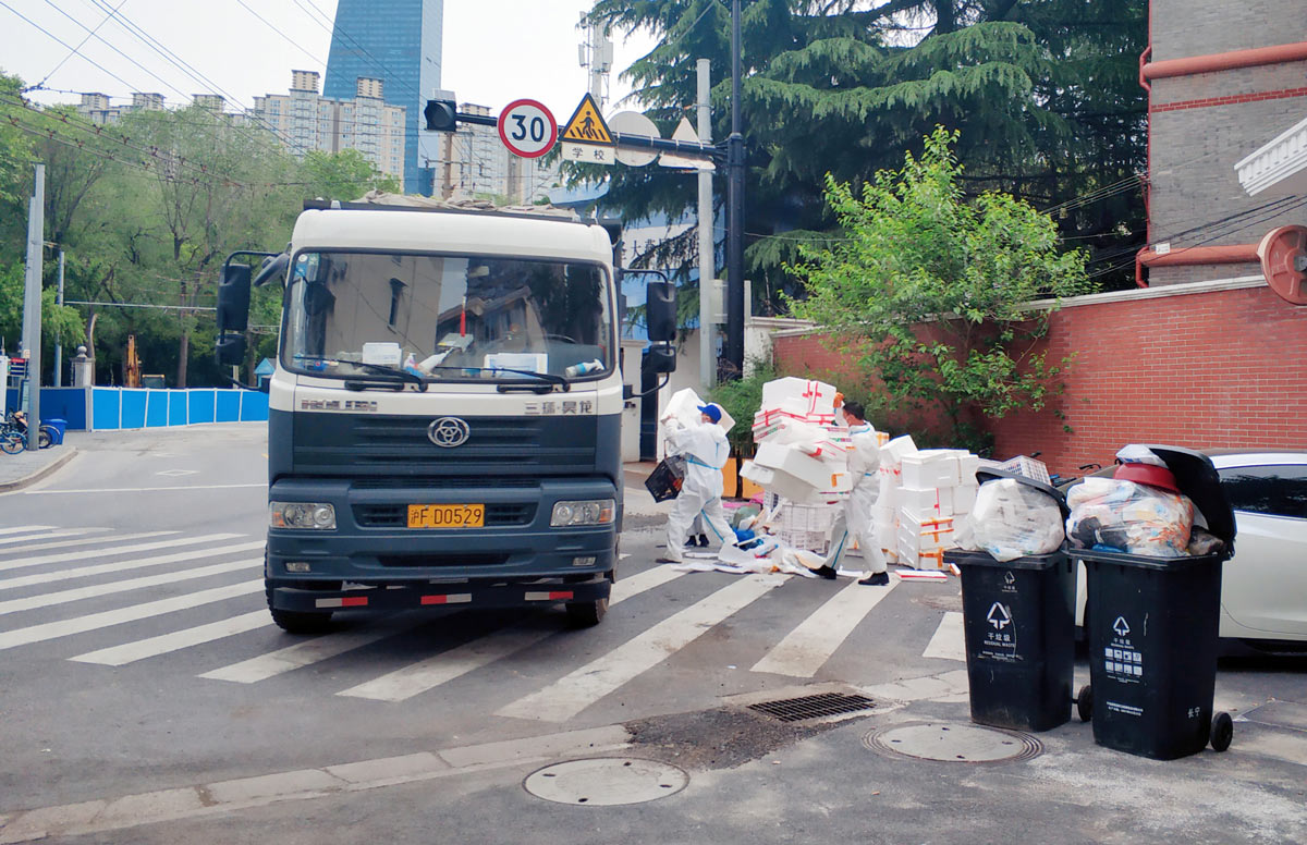 Workers transfer trash during the lockdown in Shanghai, May 1, 2022. Chen Yuyu/VCG