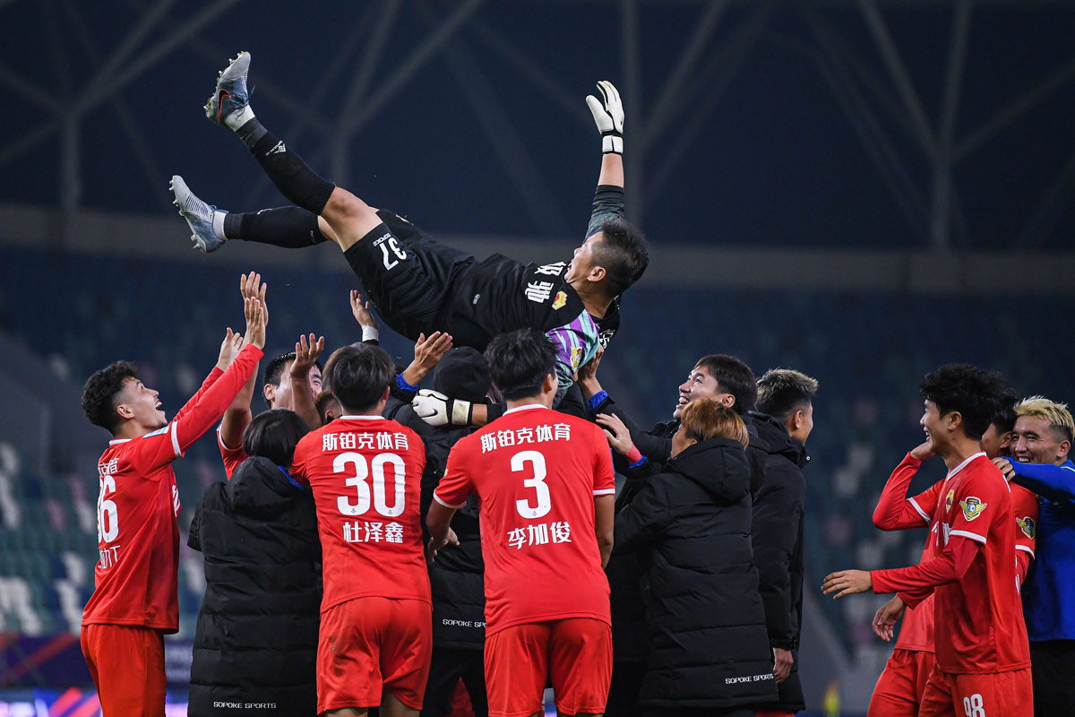 Jingchuan’s goalkeeper, Cui Tonghui, is tossed in the air by his teammates after the match against Guoan in Rizhao, Shandong province, Nov. 17, 2022. Jiang Xu/IC