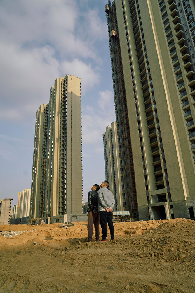 Two of the Sinic City homebuyers look up at their unfinished apartments in Nanchang, Jiangxi province, November 2022. Wu Huiyuan/Sixth Tone