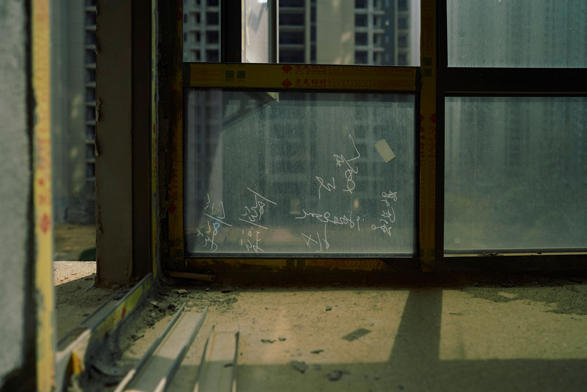 Dust covers the windows inside an unfinished apartment building in Nanchang, Jiangxi province, November 2022. Wu Huiyuan/Sixth Tone