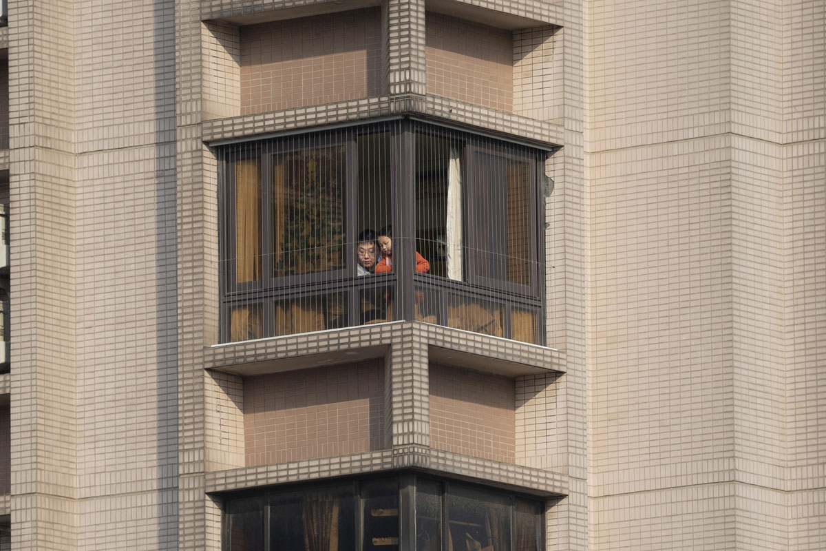 A father and daughter look through the window during the lockdown in Shanghai, May 2, 2022. VCG