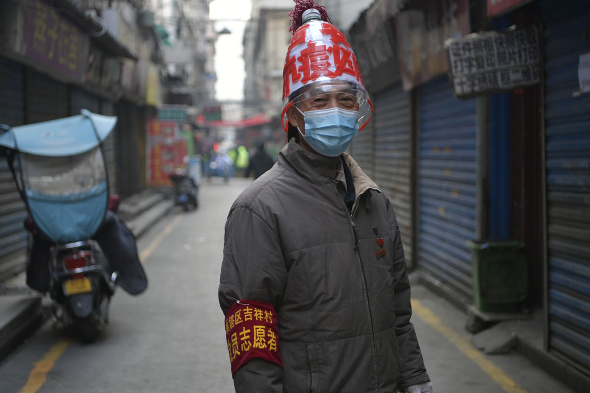 A volunteer wears a handmade helmet with pandemic prevention slogans stuck on in Xi’an, Shaanxi province, Jan. 3, 2022. VCG
