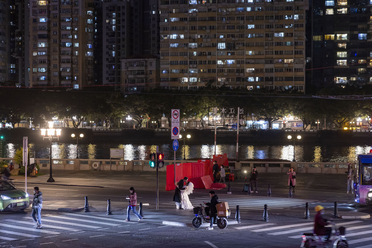A couple take their wedding photos at a crossroad in Guangzhou, Guangdong province, Dec. 3, 2022. Xiao Li for Sixth Tone