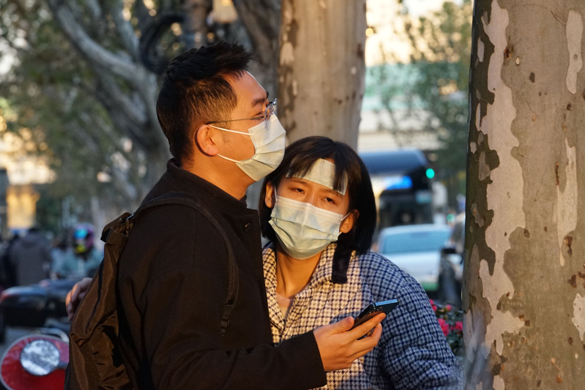 A man and woman wait outside a fever clinic in Shanghai, Dec. 19, 2022. As COVID-19 spreads, fever clinics across China are now crowded with people. VCG
