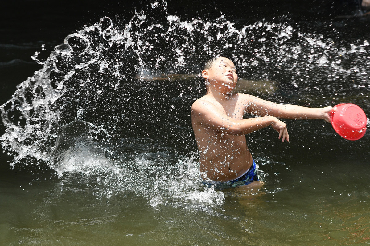 A boy enjoys Liuxi Water Splashing Carnival at Liuxihe National Forest Park in Guanghzhou, Guangdong province, July 23, 2022. In Guangzhou, the local meteorological bureau expects the hot weather to last 23 days, which would be the southern Chinese city's longest heatwave since 1951. Chen Chuhong/CNS/VCG