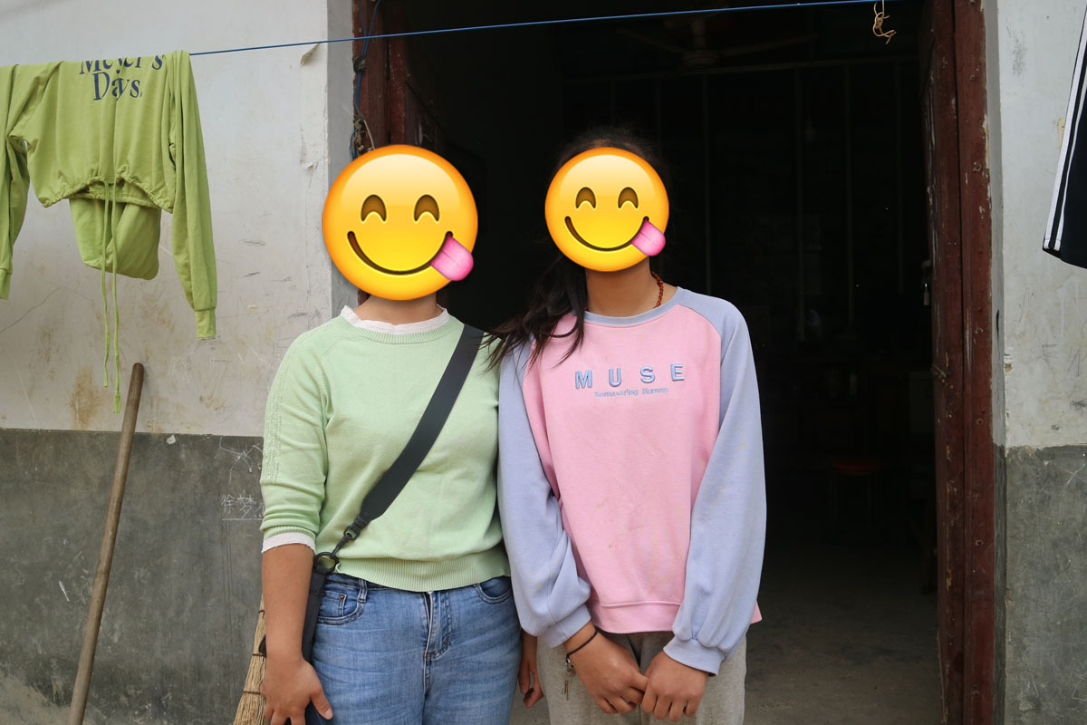 Mengge poses with her teacher, Liu Qing, 2022. The emoji were added by Xianwei Story to protect the identities of their interviewees.