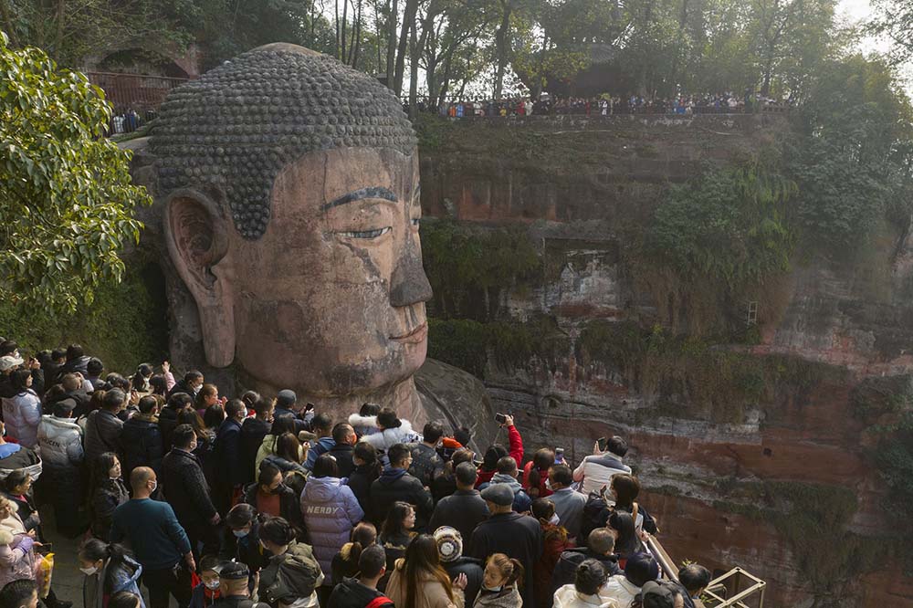 Tourists take photos of the Giant Stone Buddha at Leshan Mountain, Sichuan province, Jan. 22, 2023. Liu Zhongjun/CNS/IC