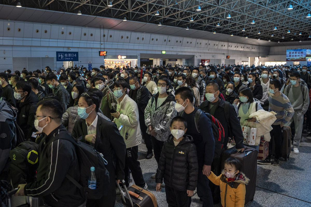 Passengers wearing face masks wait to board a high-speed train at Guangzhou South Railway Station, Guangdong province, Jan. 15, 2023. Vernon Yuen/NurPhoto via VCG