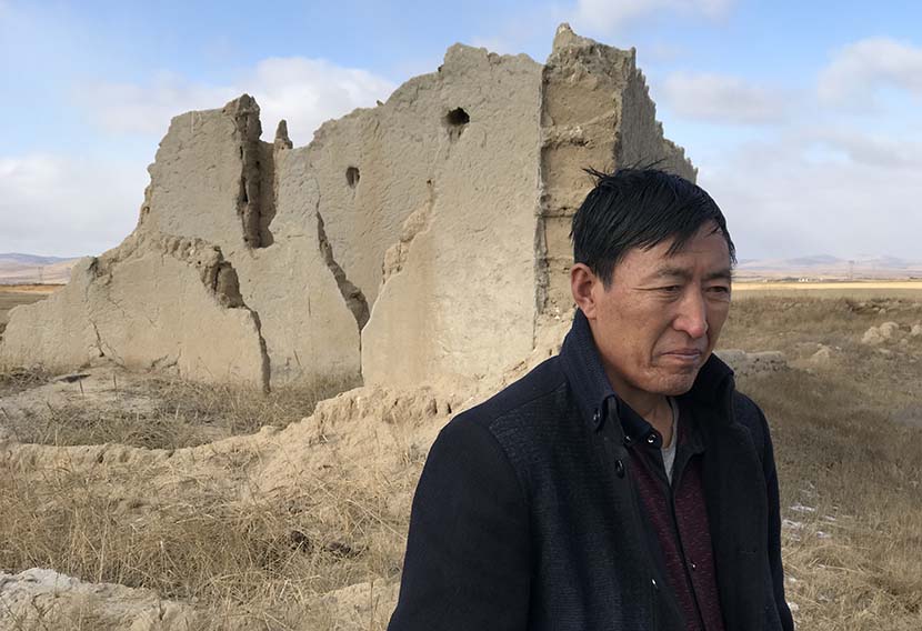 Cheng Guotian stands amid the ruins of his former prairie home, which was demolished in 2002 when his village was relocated as part of ecological migration program, Zhenglan Banner, Inner Mongolia Autonomous Region, Nov. 14, 2017. Colum Murphy/Sixth Tone
