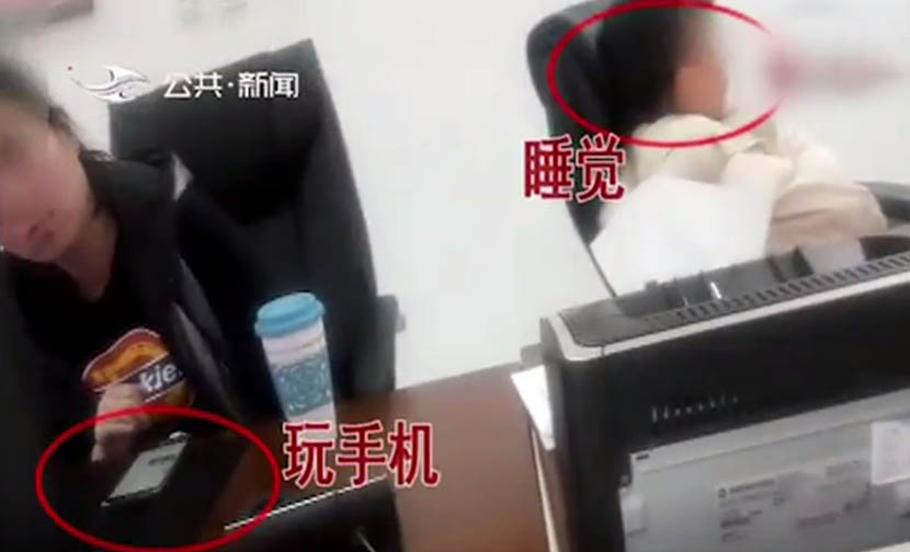 A screenshot from the undercover reporters’ footage shows two staff members sleeping on the job at the Jilin government affairs office.