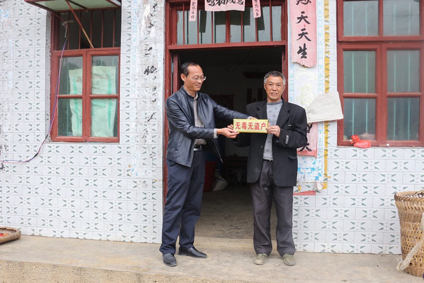 A Banchang Township official (left) awards a local man a ‘No Drugs, No Theft’ sign for his home in Yanhe County, Guizhou province. Courtesy of the Banchang Township government