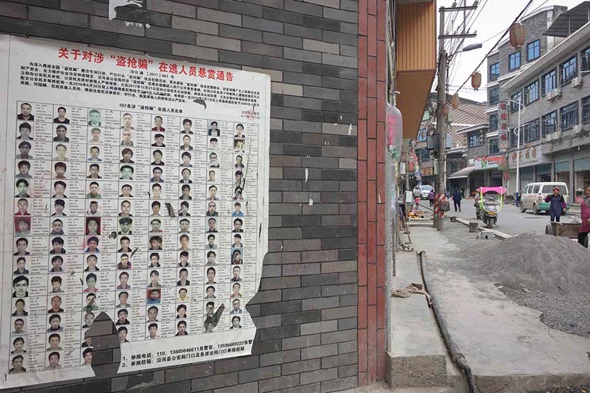 A list of wanted criminal suspects is seen on a wall in Yanhe County, Guizhou province, November 2017. Shao Ke for Sixth Tone