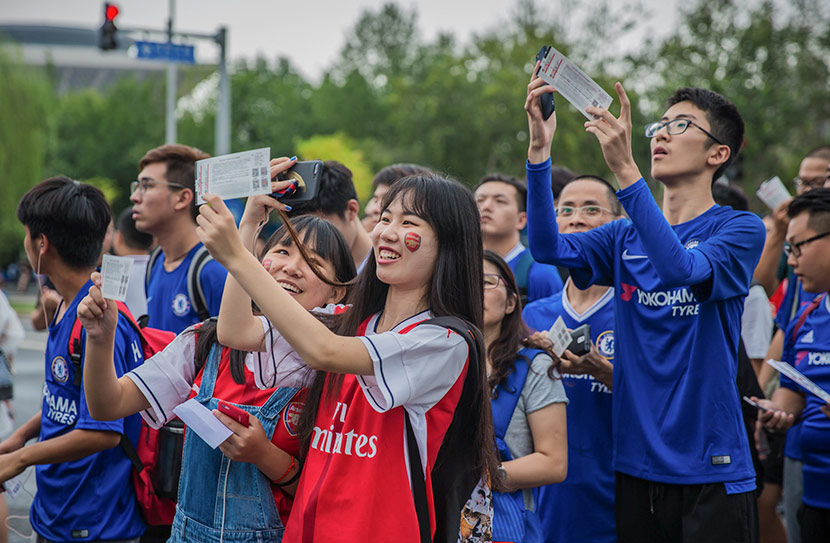 Fans of English soccer teams Arsenal and Chelsea wait to enter the stadium before a match in Beijing, July 22, 2017. Qin Ran/IC