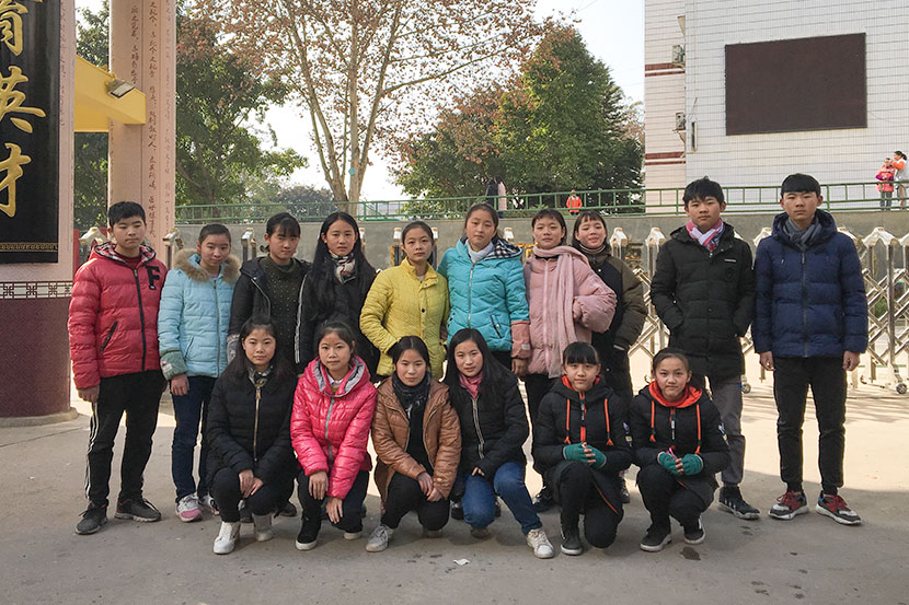 Eight sets of twins who attend Guxian Secondary School pose for a photo in front of the school’s gate in Sichuan province, Jan. 9, 2018. Fan Yiying/Sixth Tone